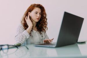 girl using laptop and hand on ears